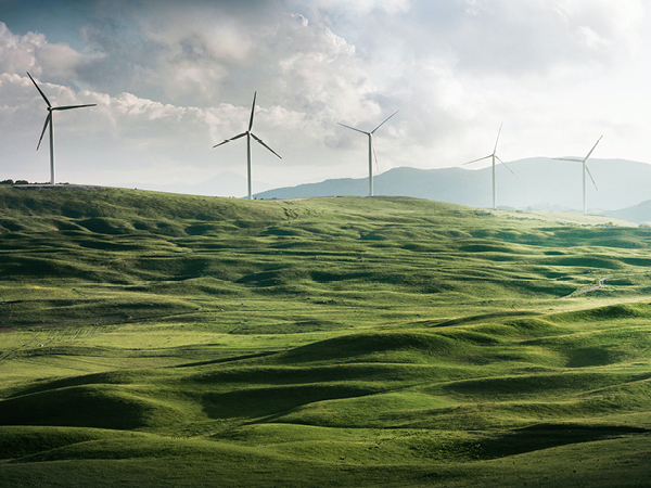 Solar panels and wind turbines as the sun sets.