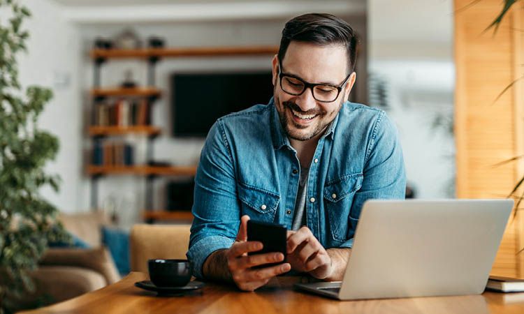 Man smiling and typing on cellphone