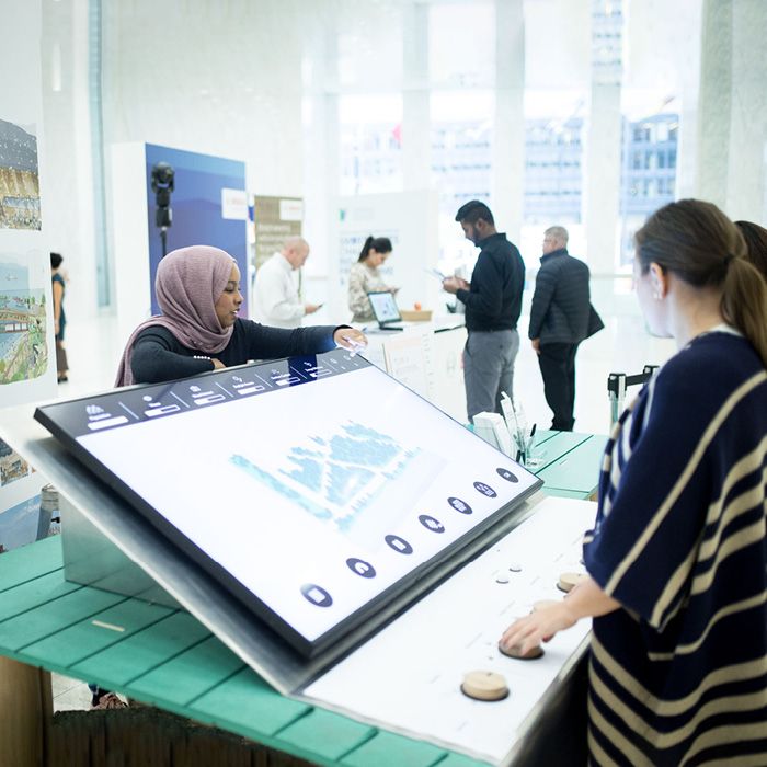 People looking at educational displays at technology showcase.