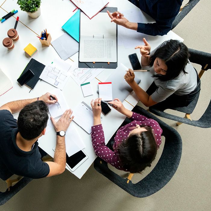 People around a table covered in documents