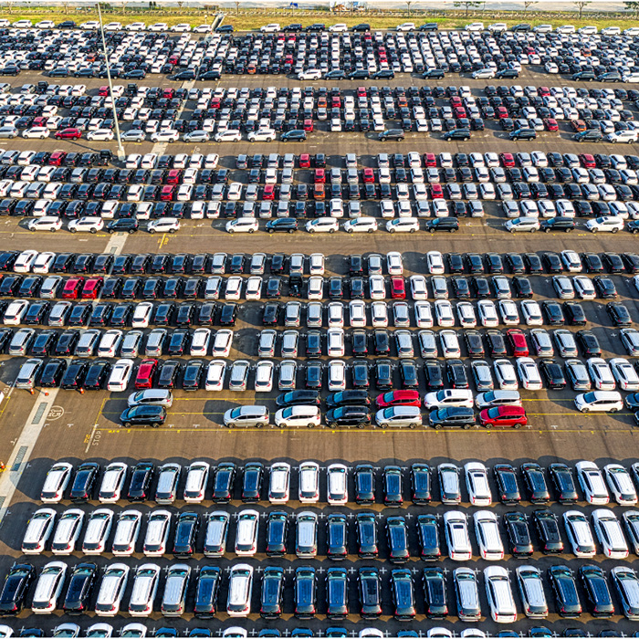 A sea of cars at in a manufacturers lot.