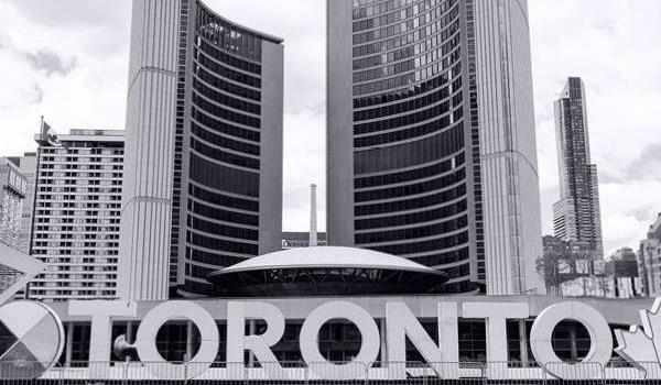 Toronto's City Hall, with the TORONTO sign in the foreground.