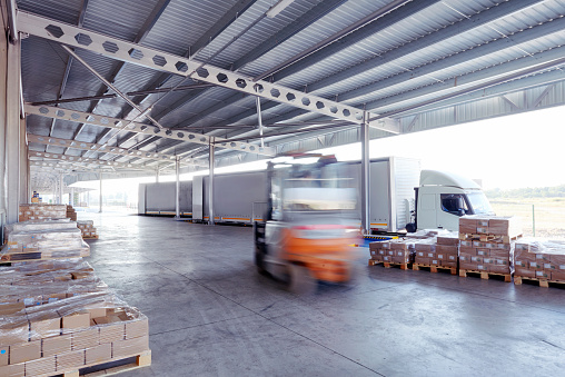 Pallets of boxes are loaded into a freight truck