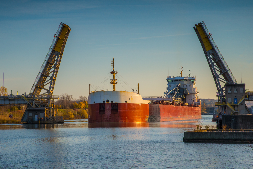 A barge passing through a raised bridge on the great lakes.
