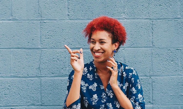 Smiling woman with red curly hair.