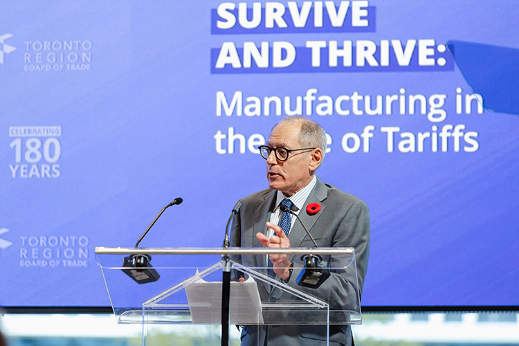 Giles Gherson speaks at a podium