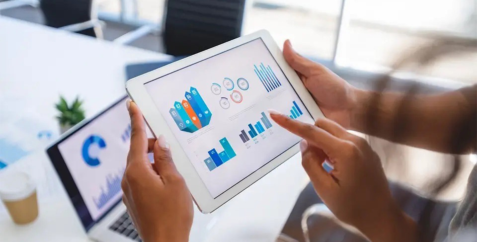 Hands on tablet looking at data dashboards